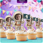 The image is a collection of cupcakes with astronaut-themed toppers, including a cupcake topper with a face and a flag.